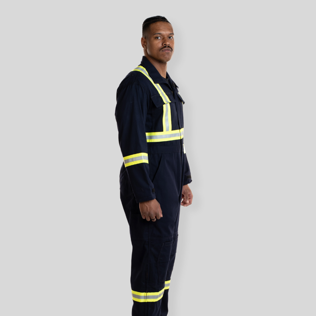 Man wearing navy coveralls with reflective striping. Navy hi-vis coveralls made from 100% cotton.