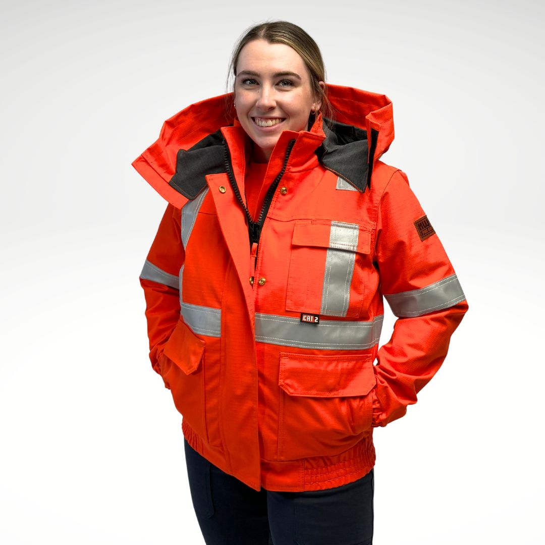 MWG STORMSHIELD Women's FR Bomber Jacket. Women's FR Jacket is bright orange with silver reflective striping on torso and sleeves for high-visibility. Women's FR Jacket has 4 front pockets with flaps and a large detachable hood. Women's FR Jacket has elastic cuffs and waist band. Women's FR Jacket is made with MWG STORMSHIELD, an inherently flame-resistant waterproof fabric. Women's FR Jacket has a CAT 2 FR rating.