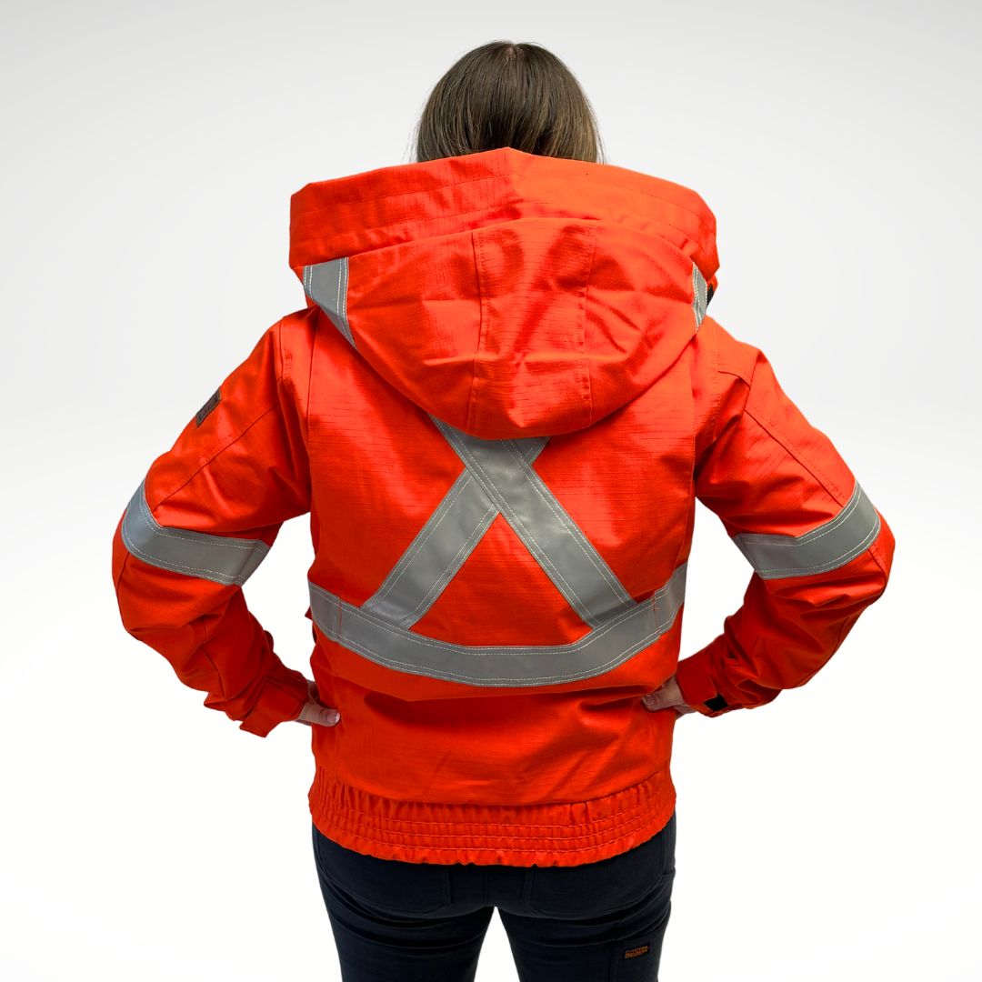 MWG STORMSHIELD Women's FR Bomber Jacket. Women's FR Jacket is bright orange with silver reflective striping on torso and sleeves for high-visibility. Women's FR Jacket has 4 front pockets with flaps and a large detachable hood. Women's FR Jacket has elastic cuffs and waist band. Women's FR Jacket is made with MWG STORMSHIELD, an inherently flame-resistant waterproof fabric. Women's FR Jacket has a CAT 2 FR rating.