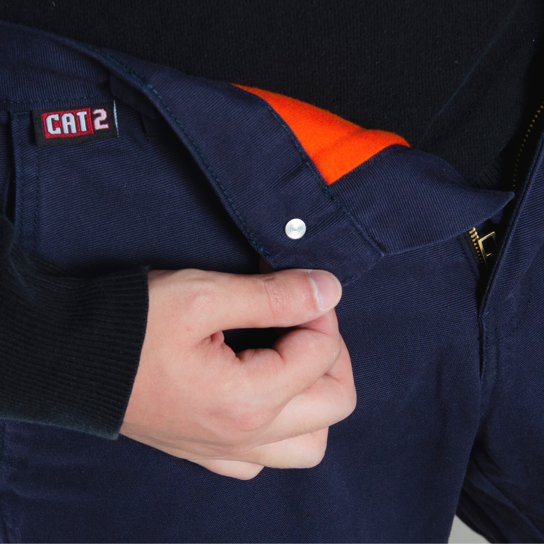 Close up image of MWG FLEXGUARD FR//AR Lined Stretch Canvas Utility Pant. Lined FR Stretch Pant is navy in colour with silver segmented reflective tape for high-visibility. Navy FR Pant has orange lining for warmth in the winter. MWG FLEXGUARD is a flame-resistant canvas.