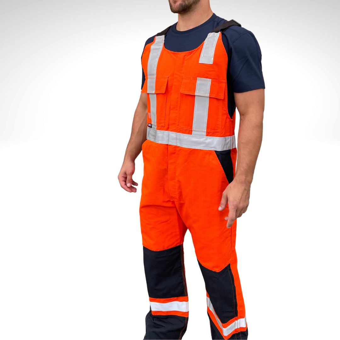 MWG RIPGUARD Men's FR Bib Overall. Men's FR Overall is bright orange and navy with silver reflective striping on torso and legs for high-visibility. FR Overalls have two chest pockets with flaps, two FR leg zippers, and a front FR zipper. FR Overalls have black FR adjustable shoulder straps. FR Overalls are made with MWG RIPGUARD, a flame-resistant ripstop fabric. FR Overalls have a CAT 2 FR rating.