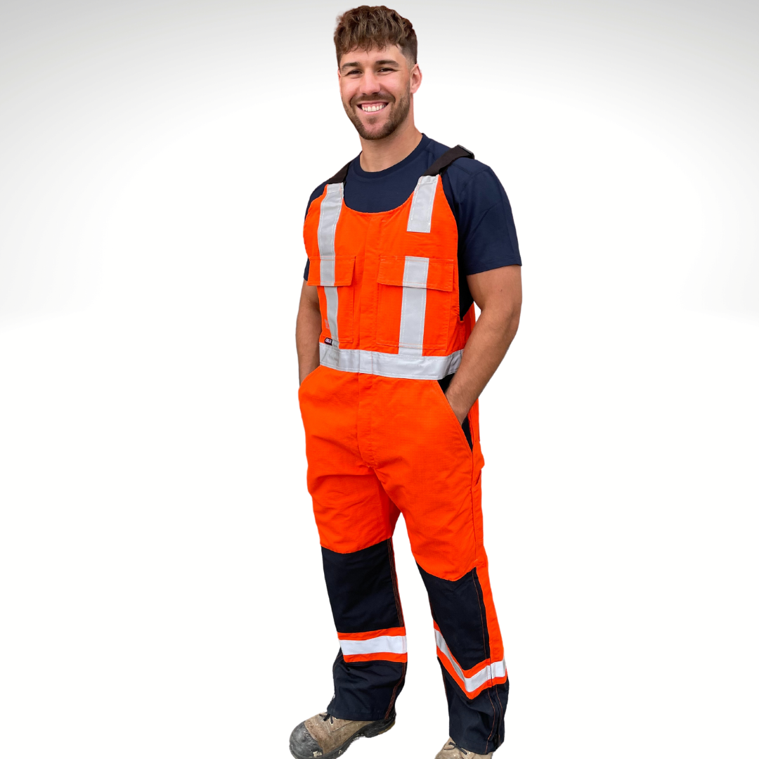 MWG RIPGUARD Men's FR Bib Overall. Men's FR Overall is bright orange and navy with silver reflective striping on torso and legs for high-visibility. FR Overalls have two chest pockets with flaps, two FR leg zippers, and a front FR zipper. FR Overalls have black FR adjustable shoulder straps. FR Overalls are made with MWG RIPGUARD, a flame-resistant ripstop fabric. FR Overalls have a CAT 2 FR rating.