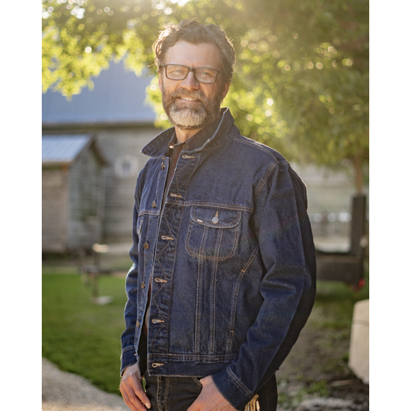 Image of MWG Storm Rider Denim Jacket. MWG Denim Jacket is navy in colour with gold stitching. Image displays front chest pocket. Model is wearing the denim jacket with collar up.
