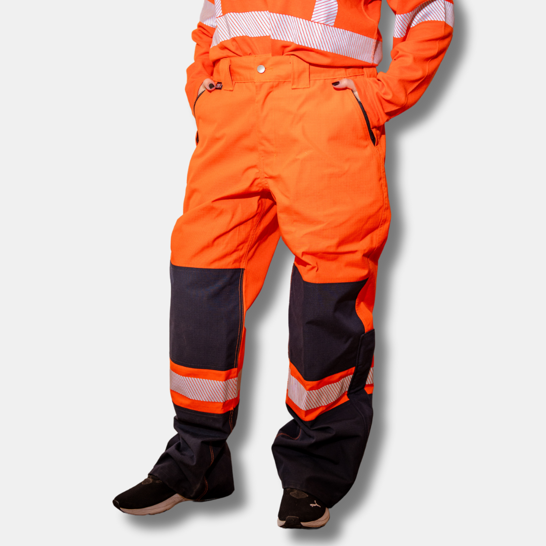 MWG STORMSHIELD Women's FR Rain Pant. Women's FR Rain Pants are bright orange and navy with silver reflective on lower leg.