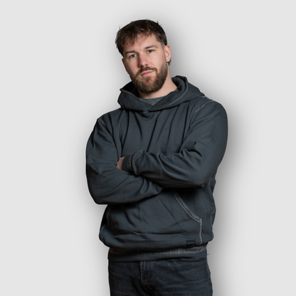Man wearing a dark gray hoodie against a light gray background