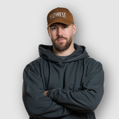 Man wearing a brown cap with 'Midwest' text and a dark hoodie against a white background