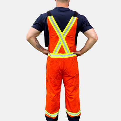 Image of MWG COTTON COMFORT FR Bib Overall. The FRC bib overall is bright orange and navy in colour, with yellow/silver/yellow reflective tape on torso and legs. Image shows two large front pockets on chest and two front slant pockets on hips. Overall is made with MWG COTTON COMFORT flame-resistant (FR) cotton.