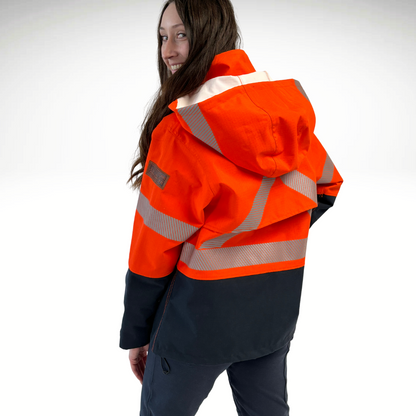 MWG STORMSHIELD™ Women's FR Rain Jacket. Women's FR Rain Jacket is bright orange and navy with silver reflective striping on torso and sleeves. Inherent flame-resistant fabric.