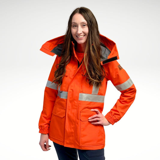 Image of women's FR parka jacket. Women's FR Parka is bright orange in colour with silver reflective tape on torso and arms. Inner lining is MWG BLOCKER fleece, bright orange in colour. 4 large front pockets and hood flaps are seen in image. Women's FR Parka is made with an inherent flame-resistant (FR) fabric. Zips in to women's FR freezer jacket and women's FR hoodie.
