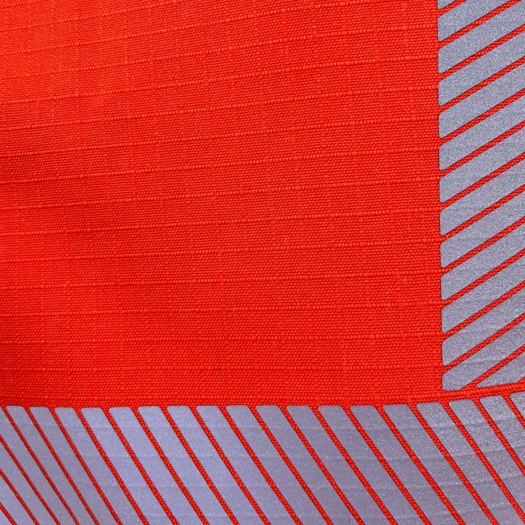 Close up image of MWG STORMSHIELD - a flame-resistant ripstop fabric. STORMSHIELD is 100% water and windproof. Close up also shows heat-applied silver segmented reflective striping for high-visibility.