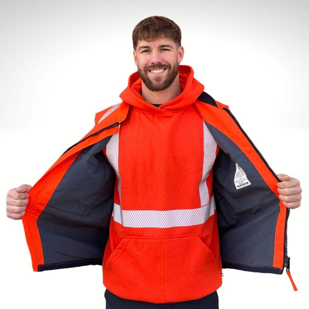 MWG STORMSHIELD Men's FR Vest. FR Vest is bright orange and navy with silver reflective striping for high-visibility. FR Vest has a dark grey FR lining. FR Vest is bring worn over bright orange FR hoodie. FR Vest is made in Canada and has a CAT 2 FR rating.