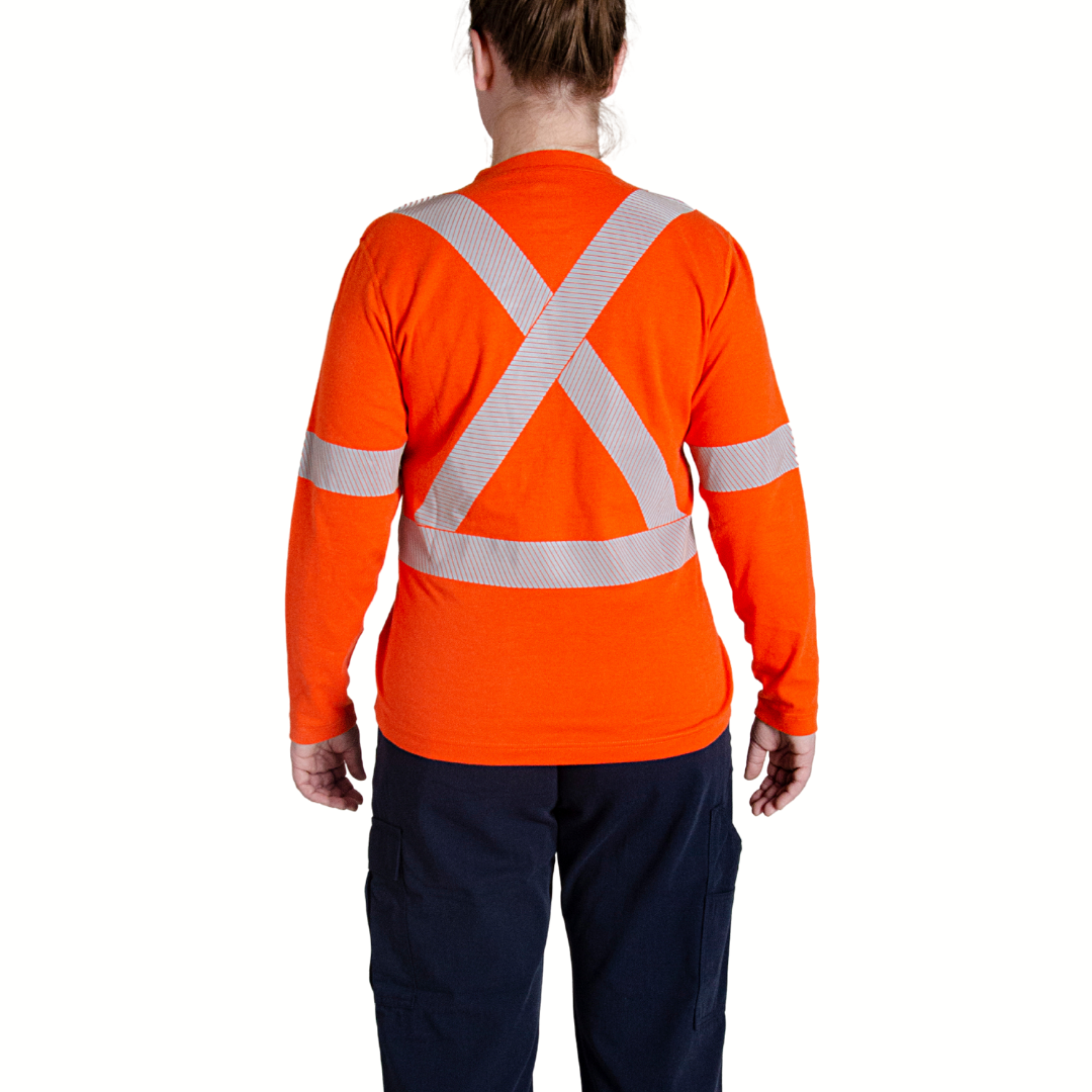 Image of MWG EVOLUTION Women's FR T-Shirt. MWG EVOLUTION FR Shirt is bright orange with silver segmented reflective striping in an X on the upper back to meet high-visibility standard CSA Z96-15. Model is wearing MWG EVOLUTION FR Shirt with women's FR utility pants.