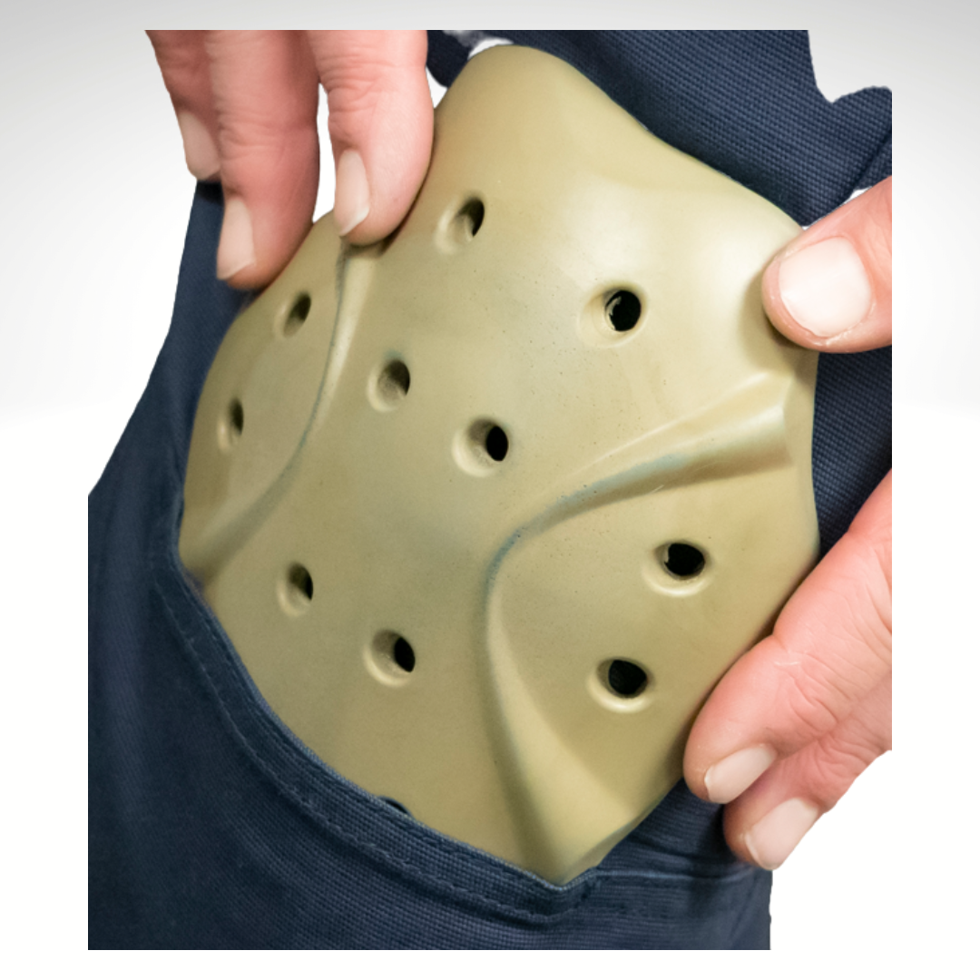 Image of knee pad sliding into pocket in MWG FLEXGUARD FR Utility Pant. Knee pad is light beige and FLEXGUARD pant is navy in colour. Knee pads offer low profile protection and are worn by armed forces.