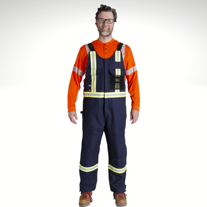 Image of MWG Duck Canvas FR Bib Overall. FR Overall is navy in colour with yellow/silver/yellow reflective tape on torso and arms. Image displays two large front pockets - mesh pocket on left chest. FRC Overall straps are black in colour. Overalls are made with an inherent flame-resistant (FR) canvas.