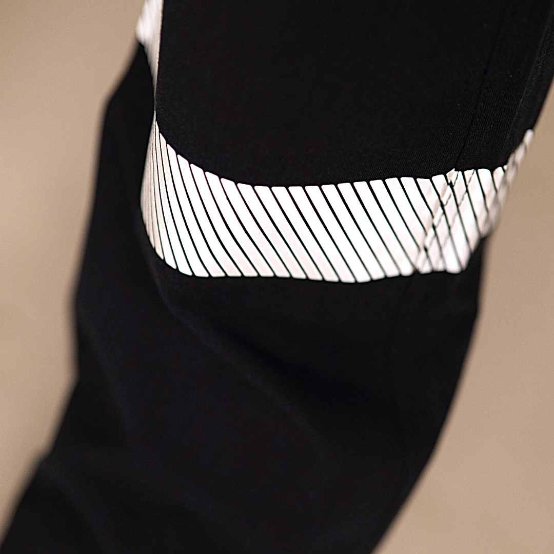 Close up image of silver segmented reflective striping on lower leg of MWG COMFORT WEAVE Women's FR Cargo Pant. Silver segmented reflective striping is used for visibility. Heat-sealed for lightweight and less bulk.