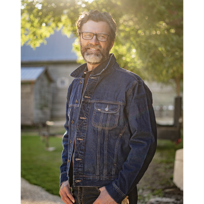 Image of MWG Storm Rider Denim Jacket. MWG Denim Jacket is navy in colour with gold stitching. Image displays front chest pocket. Model is wearing the denim jacket with collar up.