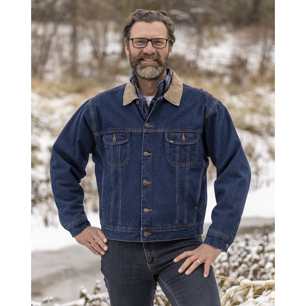Image of MWG Storm Rider Lined Denim Jacket. MWG Storm Rider Jacket is dark navy in colour with gold stiching and a tan corduroy collar. Jacket has gold buttons and two large chest pockets. Model is wearing MWG Jean Jacket with MWG stretch denim blue jeans.