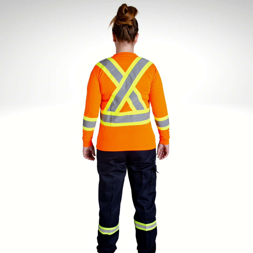 Image of MWG Women's Hi-Vis Long Sleeve T-Shirt. Bright orange in colour with yellow-silver-yellow reflective tape on upper back and sleeves. Designed in compliance with CSA Z96-15. Model is wearing women's high-visibility t-shirt with women's hi-viz cargo pants.